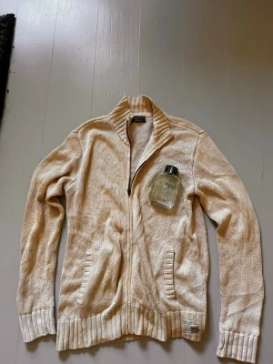 Beige stickad ziptröja - En snygg stickad cardigan från Ralph lauren, den är vintege och ovanlig. Storleken är large. Enkel att passa med andra klädesplagg