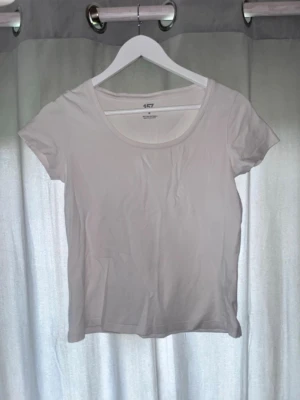 Vit basic t-shirt med rund hals - En klassisk vit t-shirt med rund halsringning och korta ärmar. Tillverkad i mjuk bomull med lite stretch för en skön passform. Perfekt att matcha med jeans eller kjol för en enkel och stilren look.
