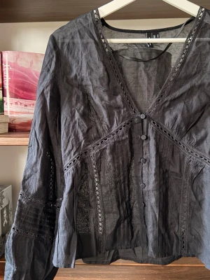 Svart transparent blus med spetsdetaljer - Snygg svart transparent blus med spetsdetaljer. Bohemisk och trendig stil, blusen är oanvänd och legat vikt sen tvätt - där av vecken. (Går bort i ny tvätt/strykjärn)                                                                        ⭐️Säljes i nyskick, utan defekter & slitage                                 💭Har du frågor? Skriv på annonsen och jag svarar så fort jag kan!