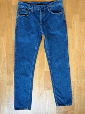 Nudie Jeans Gritty Jackson 31/32 - Säljer ett par blåa jeans med rak passform från Nudie Jeans i modellen ”Gritty Jackson” och färgen ”90s stone”. Storleken på jeansen är W31/L32 och är i ett använt skick. Perfekta till en avslappnad stil. Hör av dig om ni har några frågor