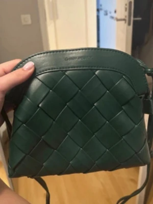  Ny Mörkgrön flätad axelväska - Snygg mörkgrön handväska med flätad läderlook och rundad form. Väskan har axelrem och minimalistisk design, perfekt för dig som gillar stilrena accessoarer. Passar till många olika outfits och ger en trendig touch.
