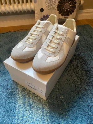 Maison margiela vita  - Säljer ett par fina maison margiela skor som knappt har använts, har bara haft de inomhus och testat men de va lite för små för mig:) skriv om du har några frågor! 