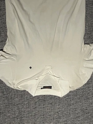 Vit pikétröja från Morris - Klassisk vit pikétröja från Morris med liten broderad logga på bröstet. Tröjan har krage och korta ärmar, tillverkad i mjuk bomull som känns skön mot huden. Perfekt för en clean och stilren look.
