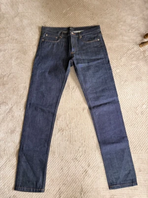 A.P.C. Petit New Standard jeans  - A.P.C. Petit New Standard jeans i mörkblå denim, 100 % bomull. Klassisk slim fit och fint använt skick.  Storlek: W32/L32 Midjemått: 88 cm Innerbenslängd: 86 cm  Visar naturlig användning och fin denim-färgning.