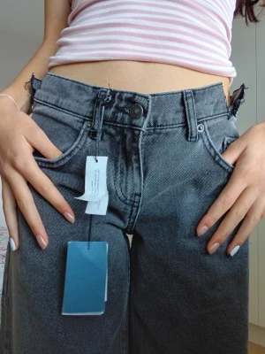 Subdued Jeans - Säljer ett par jättesnygga, gråsvarta jeans från Subdued i storlek 36.🩶🖤👖 Modellen är "Low Waist" och har en design med asymmetrisk linning och snygga cut-outs på sidorna. De har snygga, råa klippta kanter vid midjan vilket är en medveten designdetalj från Subdued! 😻Helt nya och oanvända med prislapparna kvar. 💫Jag säljer dem eftersom jag redan har liknande jeans och för att de är lite för korta för mig. Jag är 166 cm lång för referens. Alla originaltaggar sitter kvar. 💰360 kr + frakt