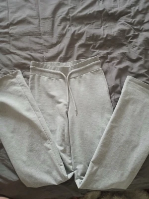 Ljusgrå mjukisbyxor från 157 XS - Ljusgrå mjukisbyxor från 157 i storlek XS. Byxorna har resår i midjan med dragsko och raka ben. Tillverkade i mjukt och bekvämt material, perfekta för chill dagar. Klassisk och enkel design som passar till det mesta.