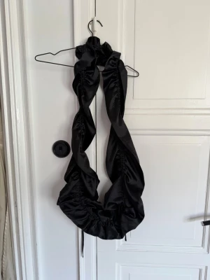 Opera Sport - Svart axelväska i satin-look - En riktigt stor scrunchie i svart, glansigt satinmaterial. Den har en voluminös och twistad design som ger en unik look till håret. Perfekt för dig som vill ha en statement-accessoar och älskar trendiga detaljer.