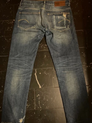 G-STAR RAW 3301 Selvage - Märke & Modell: G-Star Raw 3301 Storlek: W32 L32 (Passar M) Passform: Straight Skick: 8/10 Om plagget: Svinfeta selvage jeans med coola slitningar och fades.Tjock högkvalitativ bomull som blir ännu snyggare med användning, fin blå färg med rak passform. Info: 100% äkta | Postas inom 24h | Skriv vid frågor eller önskemål om fler bilder! 👖