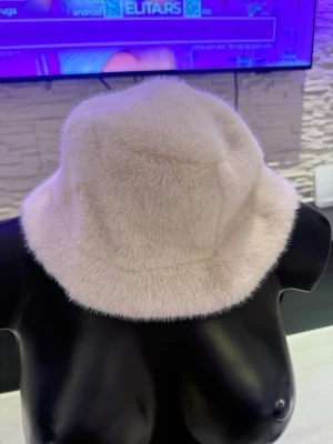 Ljusrosa fluffig bucket hat - Trendigt ljusrosa bucket hat i mjukt, fluffigt material som ger en lyxig känsla. Hatten har en klassisk form med nedåtlutande brätte och passar perfekt för dig som vill sticka ut med en cozy och modern accessoar.
