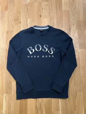 Hugo Boss Tröja - Storlek M - Långärmad Tröja från Hugo Boss för män. Plagget är nyskick, inga defekter. Storlek M, passar även S bra. Hör av dig vid intresse/frågor. PRIS KAN DISKUTERAS!