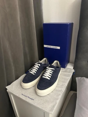 Jacob Cohën skor - Snygga marinblå sneakers från Jacob Cohën i mocka med vita tjocka sulor och vita skosnören. Klassisk låg modell som passar perfekt till jeans eller chinos. Stilsäker design med diskreta detaljer och lyxig känsla.