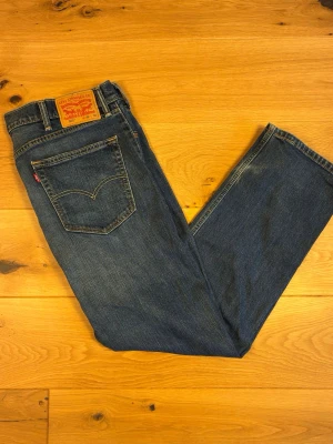 Levi's 505 W38 L30 - Klassiska Levi’s 505 i mörkblå tvätt med fina, naturliga slitningar över lår och knän. Rakt skär (straight fit) med normal midjehöjd – en tidlös passform som fungerar året runt.  Skick: Väl använda med äkta, naturligt slitage. Inga hål eller revor i själva tyget.  Detaljer:  * Märke: Levi’s * Modell: 505 * Storlek: W38 L30 * Färg: Mörkblå denim * Material: 100% bomull (denim) * Skick: Begagnat, fint allmänskick med naturlig patina