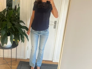 Ljusblå raka jeans med låg midja - Säljer ett par ljusblå jeans med rak passform och låg midja. Jeansen har klassisk femficksdesign och är tillverkade i denim med lätt tvättad look. Perfekta för en avslappnad och trendig stil.