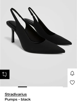 Svarta klackar från Stradivarius - Stilrena svarta sling back klackar från Stradivarius med spetsig tå och smal klack. Skorna har öppen häl med rem och är tillverkade i ett slätt material som ger en elegant look. Perfekta för att lyfta vilken outfit som helst. Har lite fläckar o avskavd färg🥰