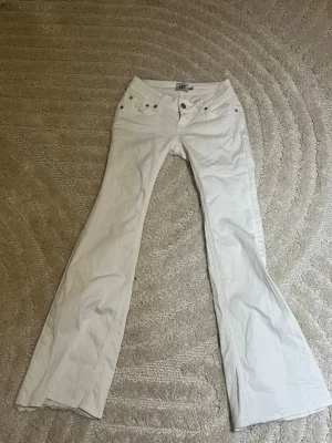 Vita utsvängda jeans med låg midja - Snygga vita jeans med låg midja och utsvängda ben. Jag har klippt där nere för att de va för långa men passar perfekt för dig som är 154..