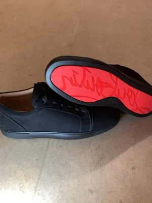 44. Christian Louboutin (nya) - Hellt nya oanvända Säljer pågrund av har börjat med löpning har inga löpar skor och behöver det akut har inga lådor eller sånt köpte länge sen har aldrig använt har råkat bli en repa på skorna pågrund av vart i en sko skåp över 7 år vet inte hur Stilrena svarta Christian Louboutin med mattsvart ovandel och matchande svarta skosnören. Skorna har en ikonisk röd sula med grafiskt mönster undertill. Låg modell med klassisk siluett och diskreta sömmar. Insidan är ljusbeige för en snygg kontrast.
