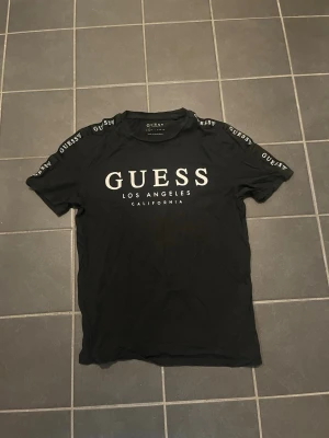 Guess t shirt Svart - Säljer denna trendiga och stiliga guess tröja som passar till de flesta tillfällena och tröjorna är inte mycket använd utan har bara legat i garderoben och därför väljer nu att sälja den. Storlek S
