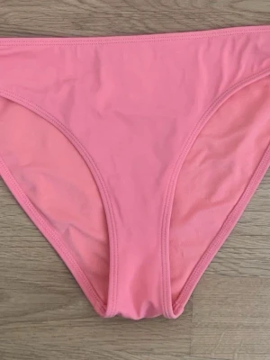 Rosa klassiska trosor - Säljer ett par enkla och stilrena trosor i en härlig rosa färg. Modellen är klassisk med medelhög midja och mjuka sömmar för extra komfort. Materialet känns stretchigt och skönt mot huden, perfekt för vardagsbruk.