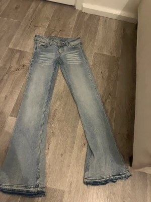 Ljusblå utsvängda jeans - Hej, jag säljer ett par weekday jeans, använda några gånger och är sprättade där nere, passar dig som är typ 158. Priset kan diskuteras. 26/32 är storleken då = 32 xs/xxs