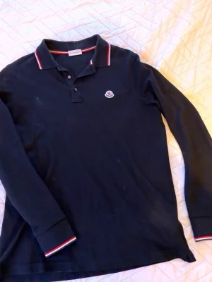 Svart långärmad piké från Moncler - Pike från moncler, fått i present och är köpt från Nk. I bra skick!