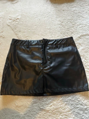 Läder kjol - Snygg läder kjol med inbygda shorts. Aldrig använd, nyskick. Går att få tvättad om så önskas. Bara att skriva om ni ha funderingar eller vill ha fler bilder!