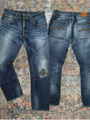 Nudie Jeans  - Riktigt snygga Nudie Jeans i modellen Sharp Bengt. Storlek 34/36 men har sytts upp till 34/34. Vänster ficka har lagats och är något mindre än högra. Det finns även en lagning på knäet. A:44,5cm B:110,5cm