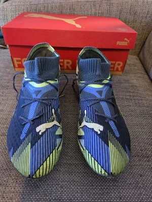PUMA Future 7 Ultimate FG/AG  - PUMA Future 7 Ultimate FG/AG  Lights Out - Grå himmel/PUMA White/Grön Storlek 40.5  Fotbollsskor för konstgräs & gräs 
