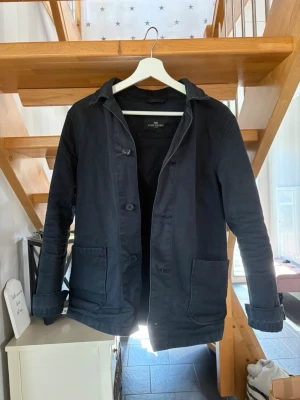 John Henric overshirt  - Exklusiv overshirt/jacka från John Henric i mörk marinblå nyans. Stilren och tidlös modell med klassisk krage, knappstängning och praktiska framfickor. Ett mångsidigt premiumplagg som passar lika bra till en avslappnad outfit som till en mer dressad look.  • John Henric • Storlek S • Mörk marinblå • Mycket fint skick • Tidlös och stilren design  💰 Pris: 699 kr  En riktigt snygg jacka för dig som gillar en klassisk och exklusiv look.