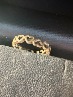 3 Silverfärgad ring med hjärtan - Snygg ring i silverfärg med ett mönster av ihåliga hjärtan runt hela ringen. Perfekt för dig som gillar romantiska detaljer och vill ha något unikt på fingret. Kommer i en stilren ask.