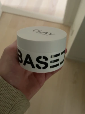 Based Bodywork’s hair clay - Säljer en vit burk med hårlera från BASED. Burken har svart text och innehåller en beige, krämig lera som är enkel att forma håret med. Perfekt för dig som vill styla håret med en matt finish och bra stadga. Har använt lite men inget fel med den