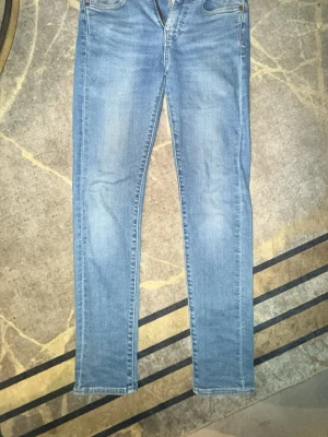 Levi’s Jeans - Säljer ett par ljusblå jeans med rak passform och klassisk femficksdesign. Jeansen har en något tvättad look och är tillverkade i denim. Perfekta för en avslappnad stil och passar till det mesta i garderoben.