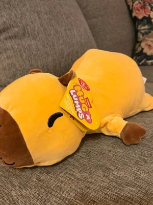 NY! ZURU Hug A Lumps Capybara 1,5kg - Mjukdjur från ZURU Hug A Lumps, föreställande en kapybara. Denna gosedjur är designad för att vara en kramgo kompis. Passar för barn från 3 år och uppåt.  Ny i kartong!