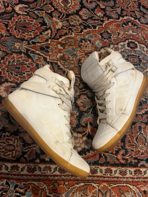 2012 Maison Margiela X H&M high top - Really cool shoes from the hm x margiela 2012 collection, they only released in 2012 and has no longer been on sale since then which marks its limitation. They good a pretty good condition in mind how old they are however I think it’s surely possible to wash of if you got the time. 
