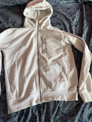 Sail racing zip hoodie - Säljer en vit hoodie med dragkedja framtill och huva. Hoodien har en bröstficka med dragkedja och diskret broderad detalj på huvan. Tillverkad i mjukt bomullsmaterial, perfekt för en avslappnad stil. 
