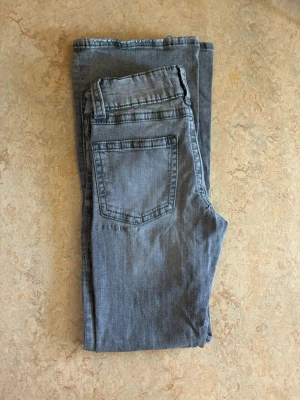 Grå jeans med dubbla knappar - Snygga gråa bootcut jeans med dubbla knappar i midjan. Klassisk femficksmodell och diskret tvättad look. Perfekta för en avslappnad och trendig stil. Skriv gärna om du undrar något😊💕