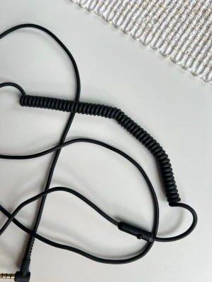 Svart spiralkabel från Marshall - En Marshall -kanel i spiral med AUX-ingång på båda sidor. Erbjuder mic för att prata i telefon och knapp för att pysa/spela/byta låt när du lyssnar på musik 🎵  Aldrig använd.