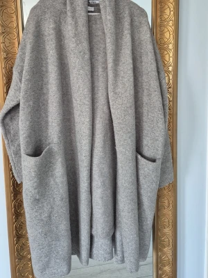 Två delar klänning och oversized kofta från ZARA - Från ZARA i mjuk gråmelerad ullmix. Koftan har öppen front, stora fickor framtill och långa ärmar. Perfekt för lager på lager och chill dagar.