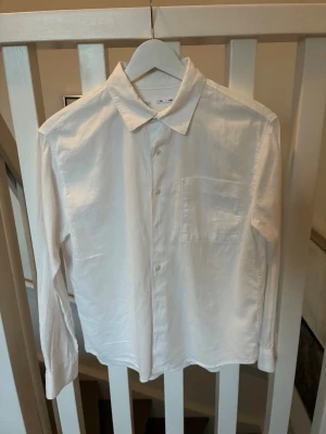 Klassisk vit linneskjorta  - Säljer en stilren vit skjorta från Zara med lång ärm och bröstficka. Skjortan har knappar framtill och klassisk krage. Perfekt basplagg till garderoben och passar till många olika stilar. Tillverkad i bomull för en skön känsla. Storlek junior 140 cm (size 10)