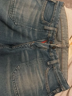 Blå tvättade raka/bootcut jeans  - Vintage från Paris!! Säljer ett par klassiska blå jeans med tvättad look och raka/bootcut ben. Jeansen har fyra fickor, bälteshällor och knappgylf. Materialet är slitstark denim i bomull. Perfekta för en avslappnad stil.