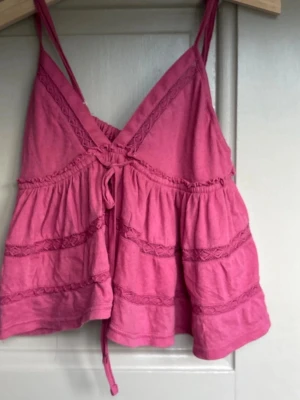 Rosa/lila topp - .Säljer en rosa/lila topp med spets och knyt framtill, från urbans outfiters-storlek M