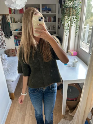 Lågmidjade blå boot cut jeans - Säljer ett par snygga blå boot cut jeans med slitningadetaljer och en låg midja.