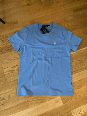 Blå t-shirt från Polo Ralph Lauren - Snygg ljusblå t-shirt från Polo Ralph Lauren, Passar Xs-S.