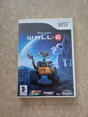 Tv-spel - Säljer spelet Wall-E till Nintendo Wii, baserat på Disney Pixars film. Omslaget är blått med motiv av robotarna Wall-E och Eve på en rymdbakgrund. Spelet är för spelare från 3 år och kommer i ett plastfodral med färgglad grafik.