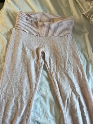 Ljusrosa mjukis yoga pants från Gina Tricot - Mysiga ljusrosa mjukisar från Gina Tricot med bred ribbad midja. Mjukt stickat material som känns skönt mot huden. Perfekta för en chill dag hemma eller när du vill ha något bekvämt på dig.