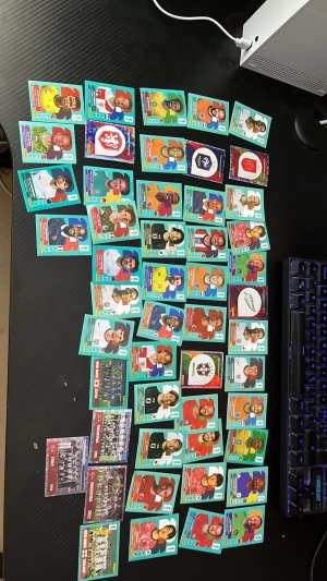 Panini 2026 VM Stickers - Säljer en stor samling fotbollskort med spelare och lag från olika nationer och VM-turneringar. Korten är färgglada och har porträtt, landslagsloggor och lagbilder. Blandade motiv från bland annat Italien, Argentina, Japan och England. Perfekt för dig som gillar fotboll och samlarprylar. Ungefär 50 st 