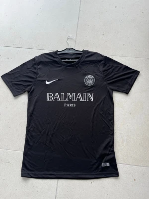 Svart PSG fotbollströja  - Svart kortärmad PSG tröja som är i storlek S men det är en stor S så passar både S och M.                         Den är perfekt för sommaren.                     Hör av dig vid minsta lilla fundering !       MVH larre! 