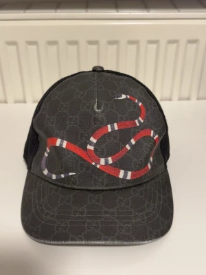 Gucci GG Kingsnake keps - Gucci GG Kingsnake keps 🐍🤩                                 - Skick: 9/10 – Använd enstaka tillfällen                     - Storlek: M ( 57 cm ), passar S                                 🚀 Snabb och spårbar frakt ingår!                            📩 DM vid köp, frågor eller om du vill ha fler bilder