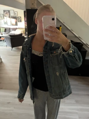 Oversized blå jeansjacka - Snygg oversized blå jeansjacka med slitna detaljer och klassiska bröstfickor. Jackan har knappar framtill och på ärmsluten samt en avslappnad passform som ger en cool och trendig look.