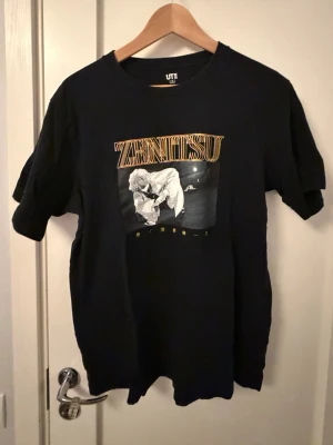 Svart t-shirt med Demon Slayer tryck - Svart T-shirt från Uniqlo med Demon slayer tryck på framsidan med Zenitsu.