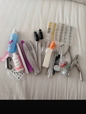 Stort nagelkit med verktyg & dekoration - Säljer ett komplett nagelkit med flera nagelfilar, buffertblock, nagelborste, pincett, nagelklippare, dotting tools, penslar, två flaskor vätska, nageldekorationer i guld och silver samt nail art stickers. Perfekt för dig som vill fixa naglarna hemma.